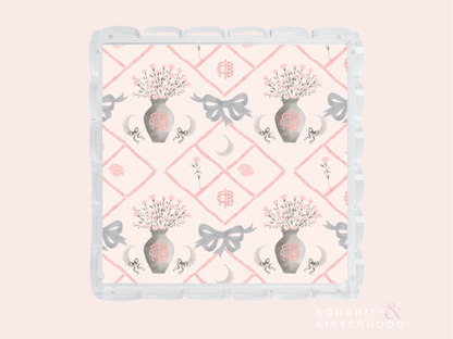 White ceramic tray with scalloped edges, pink diamond pattern, floral vases, bows, and Gamma Phi Beta symbols.