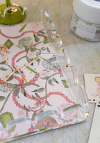 Clear acrylic tray with scalloped edges featuring a floral and pink beaded pattern on the base.