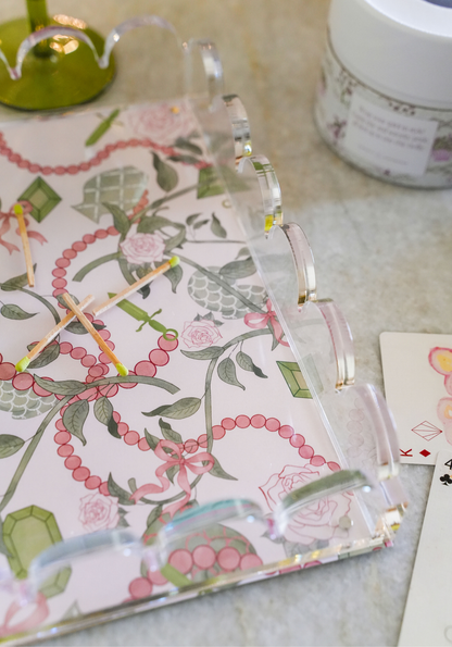 Clear acrylic tray with scalloped edges featuring a floral and pink beaded pattern on the base.