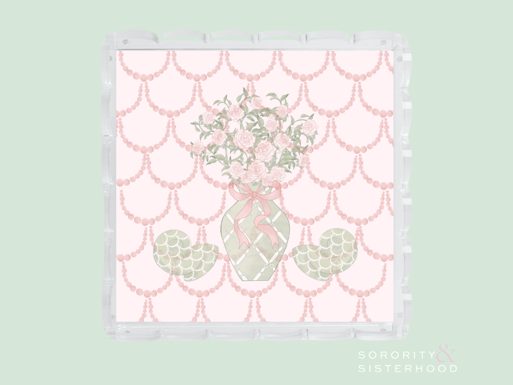 Clear acrylic tray with scalloped edges featuring a pink and green floral vase design on a pink scalloped background.