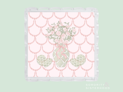 Clear acrylic tray with scalloped edges featuring a pink and green floral vase design on a pink scalloped background.