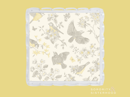 White scalloped tray with gray and yellow floral and bird pattern, clear edges.