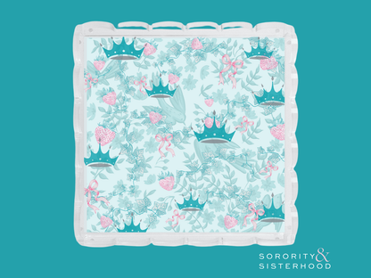 Acrylic tray with scalloped edges featuring teal crowns and pink floral pattern on a light blue background.