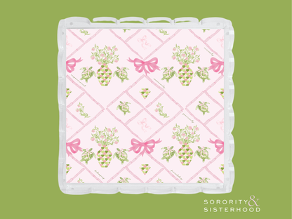 Rectangular acrylic tray with pink scalloped edges, featuring floral and green grapevine patterns with pink bows on a light.