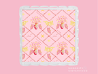 Square acrylic tray with scalloped edges, pink background, floral and butterfly pattern, gold accents.