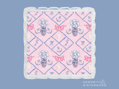 Square acrylic tray with scalloped edges, pink and blue Delta Gamma crest pattern.