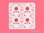 Pink and white acrylic tray with scalloped edges and red floral diamond pattern.