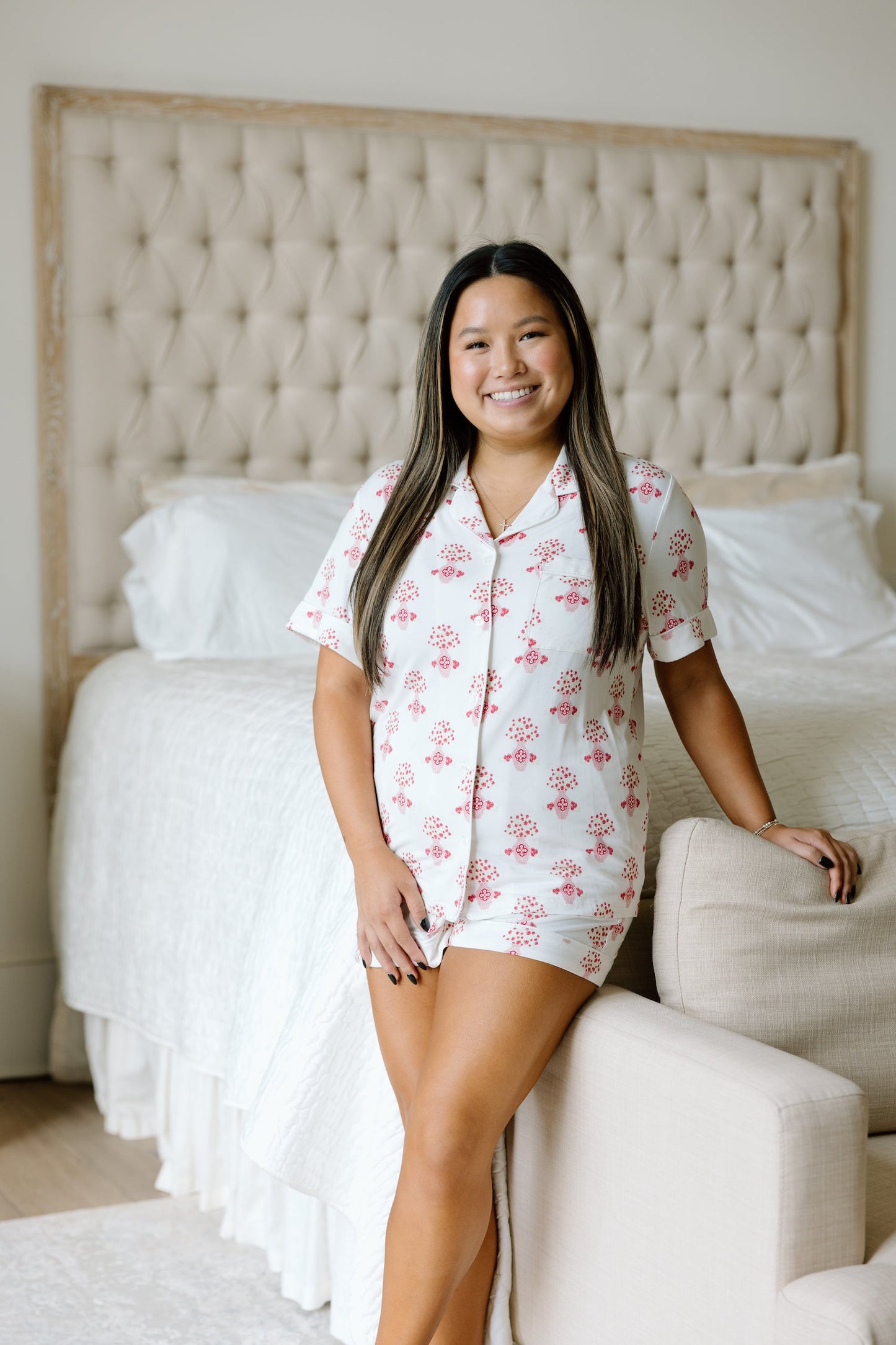 White pajama shorts set with pink floral Alpha Omicron Pi logo pattern and short sleeves.