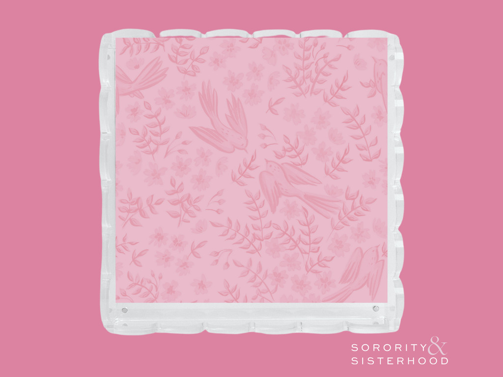 Pink acrylic tray with scalloped clear edges and subtle floral pattern.
