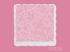 Pink acrylic tray with scalloped clear edges and subtle floral pattern.