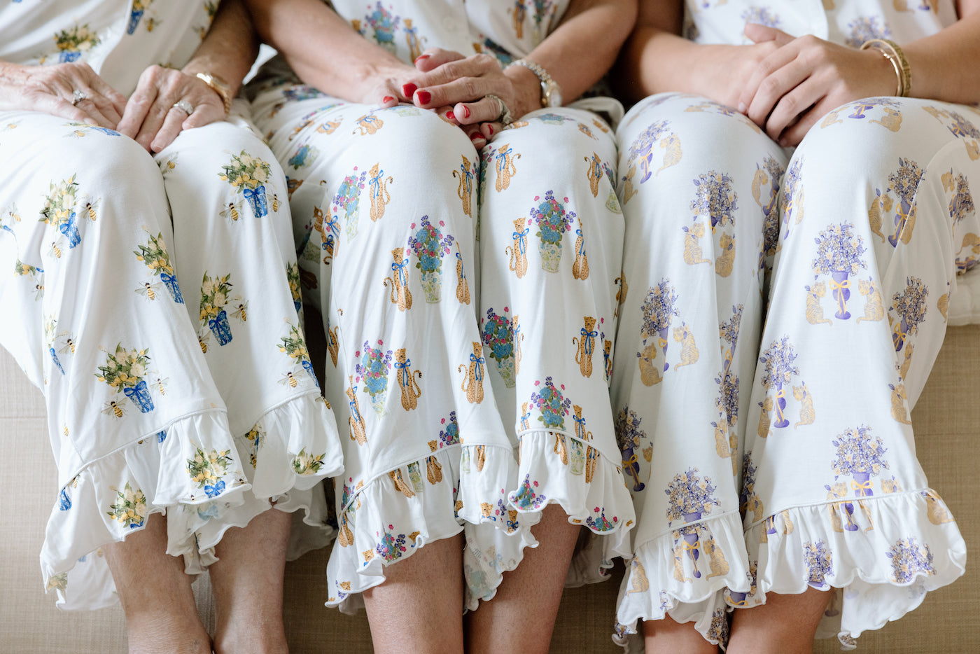 White pajama pants with purple and gold LSU Tigers fleur-de-lis print and ruffled hems.