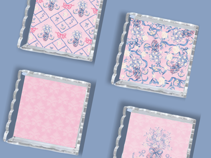 Four acrylic trays with scalloped edges, featuring pink and blue Delta Gamma floral and pattern designs.
