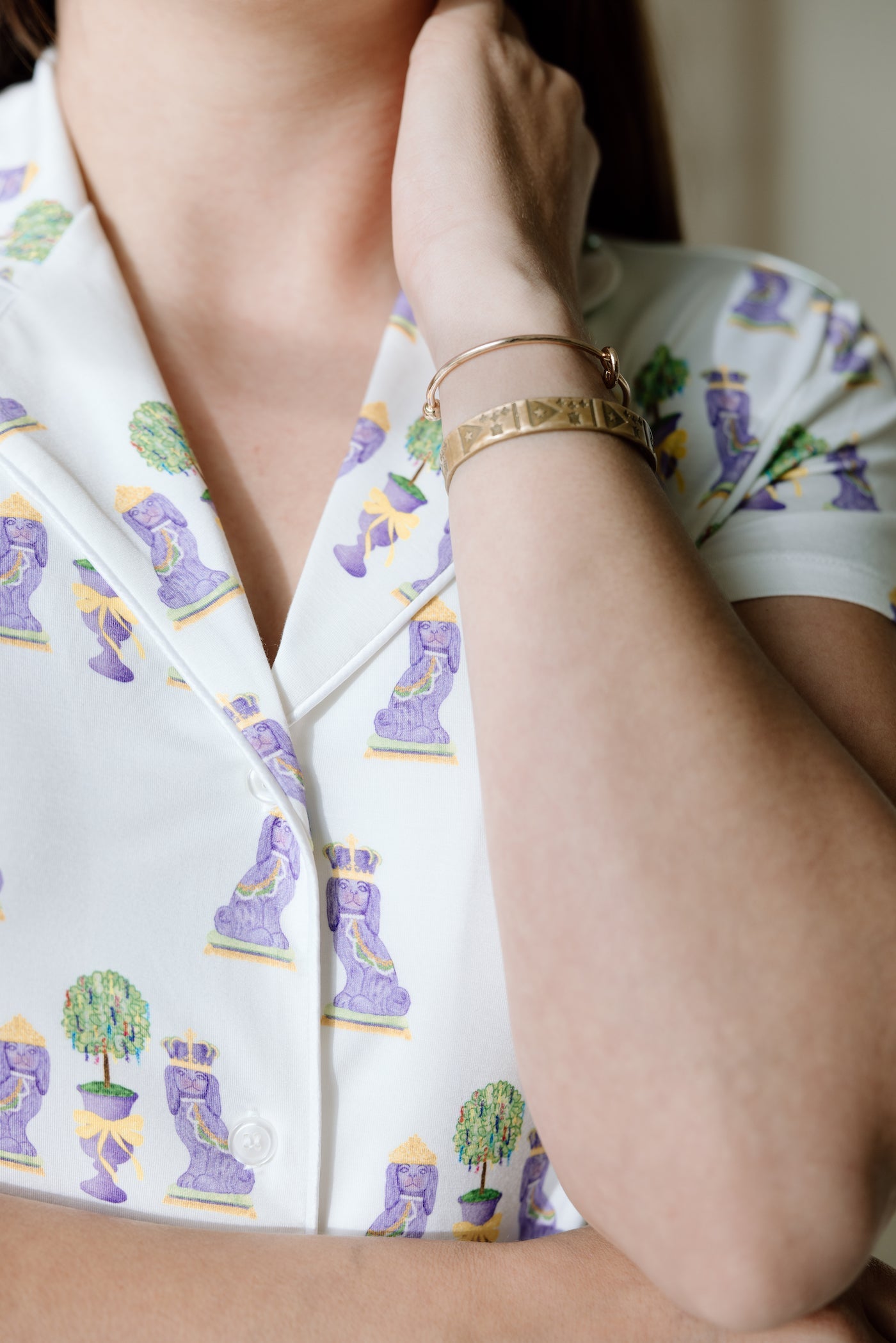 White pajama top with colorful Mardi Gras masks and trees print, button-up style with short sleeves.