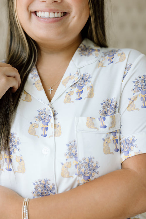 White short-sleeve pajama shirt with purple and gold floral and LSU Tigers helmet print.