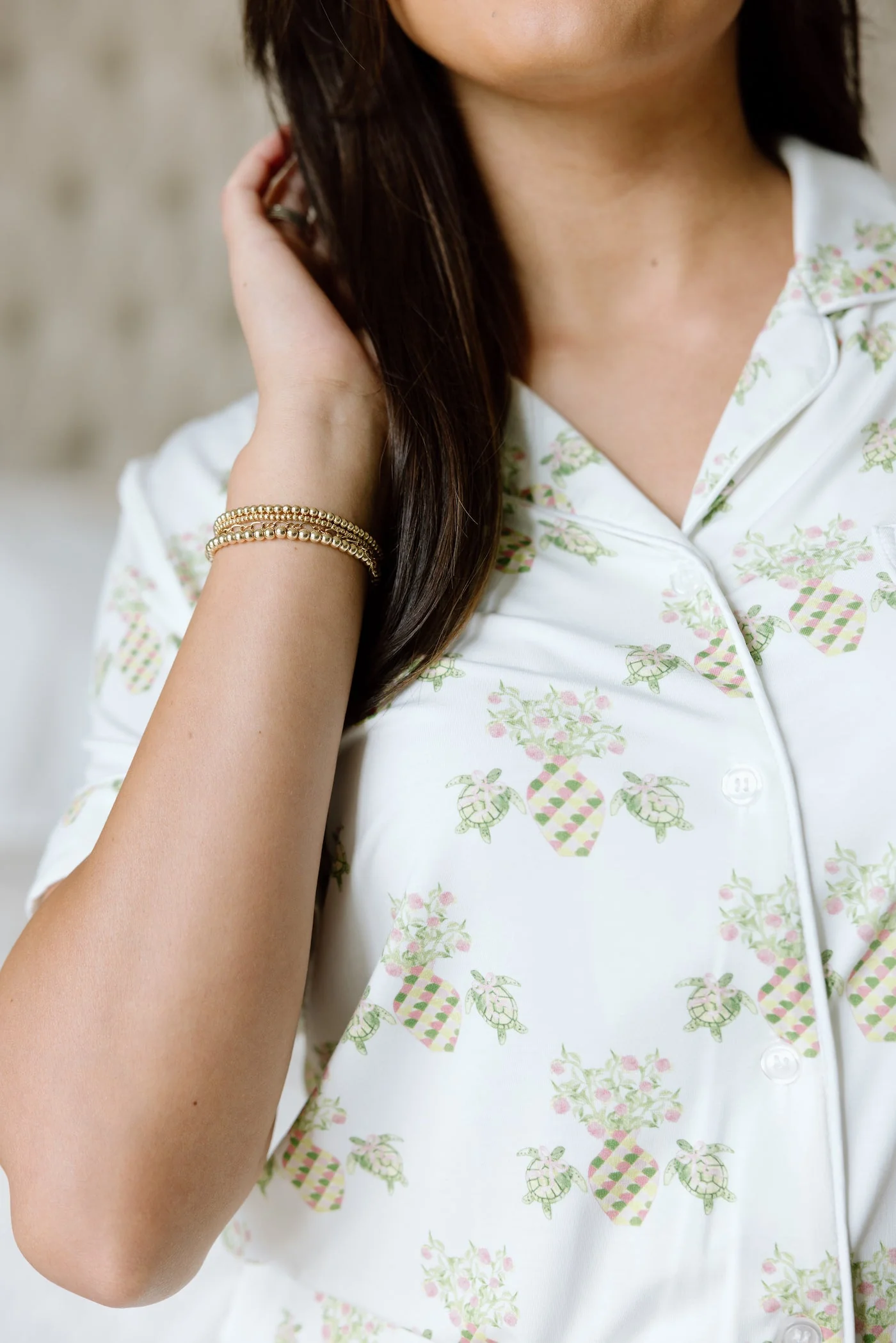 White pajama top with pink and green floral pineapple print and piped collar detail.