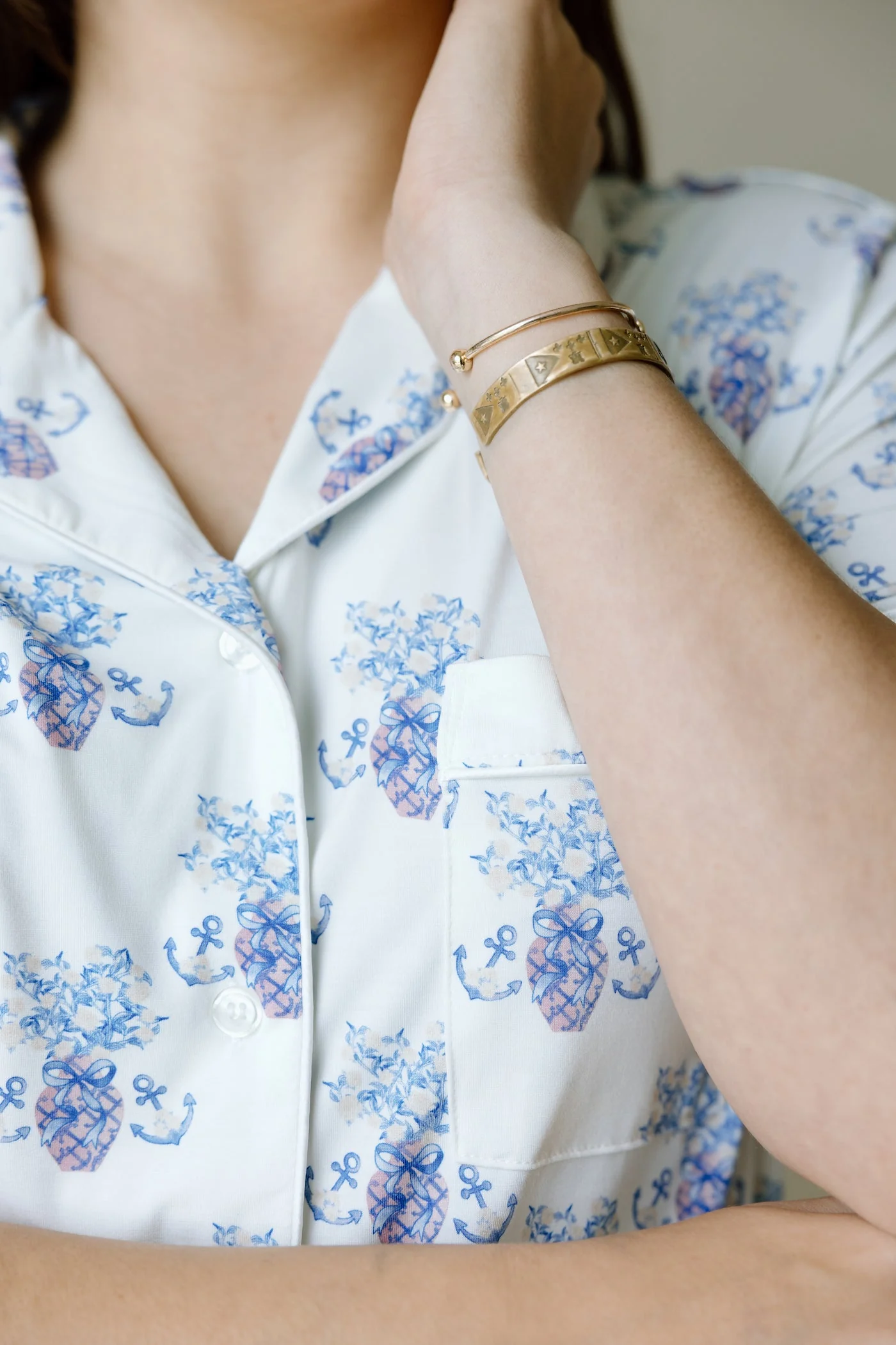 White pajama top with blue floral and anchor print, featuring a chest pocket and button-down front.