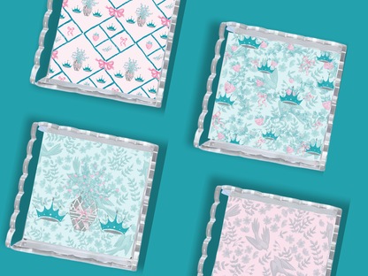 Set of three acrylic trays with scalloped edges, featuring pastel pink and teal floral and crown patterns.