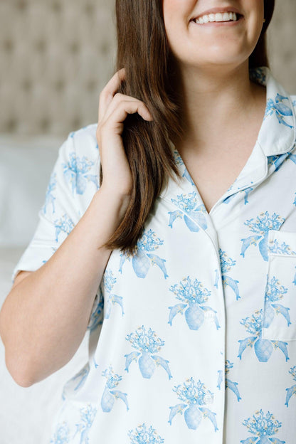 White pajama shorts set with blue floral print and button-up short-sleeve top.